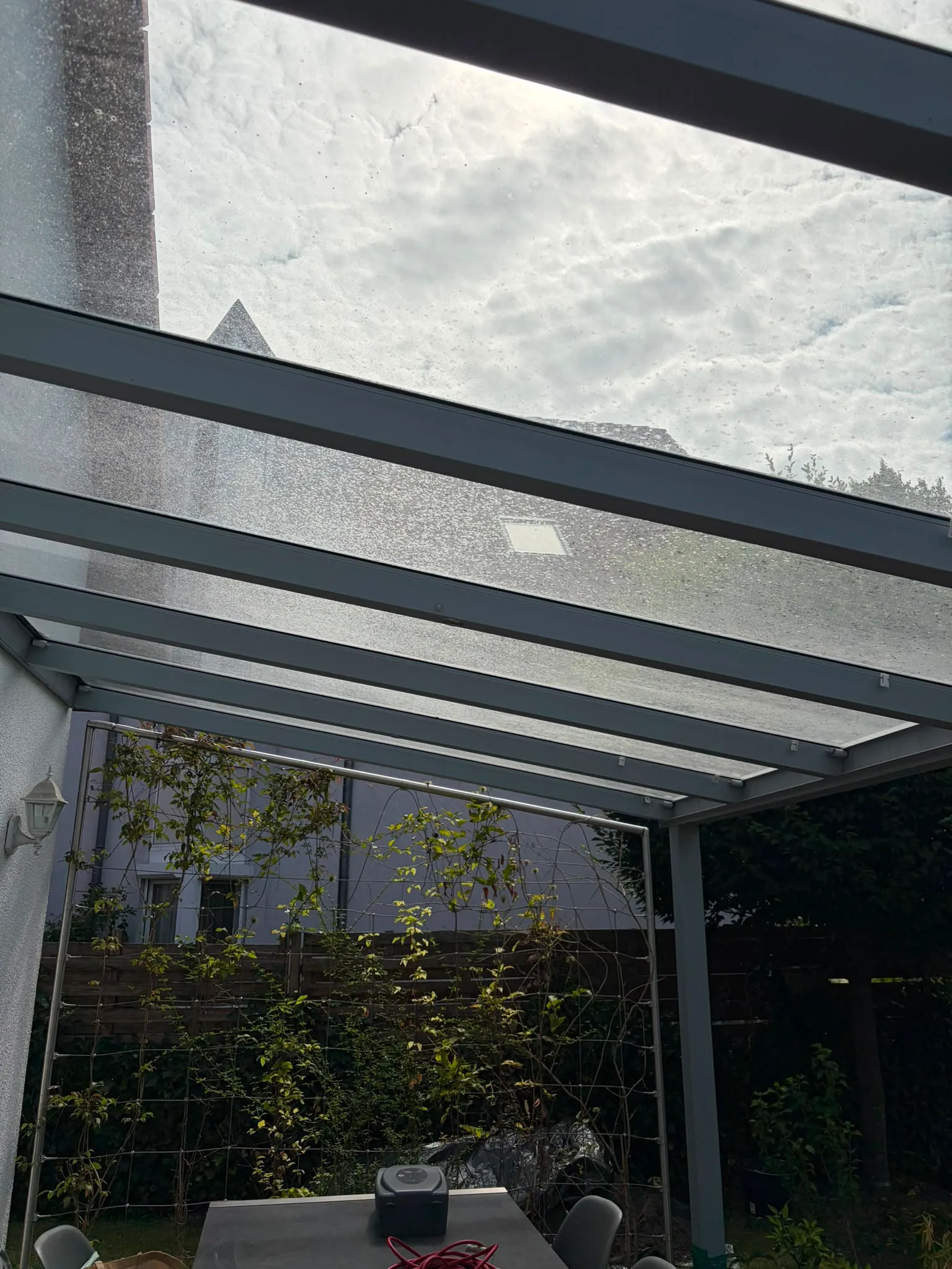 Verschmutztes Glasdach mit milchigem Belag vor der Reinigung